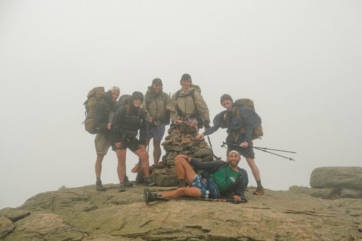 A group of thru-hikers at the summit of a peak in the Northeast.