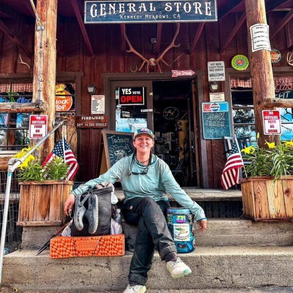 A PCT hiker taking a rest in front of the Kennedy Meadows General Store.