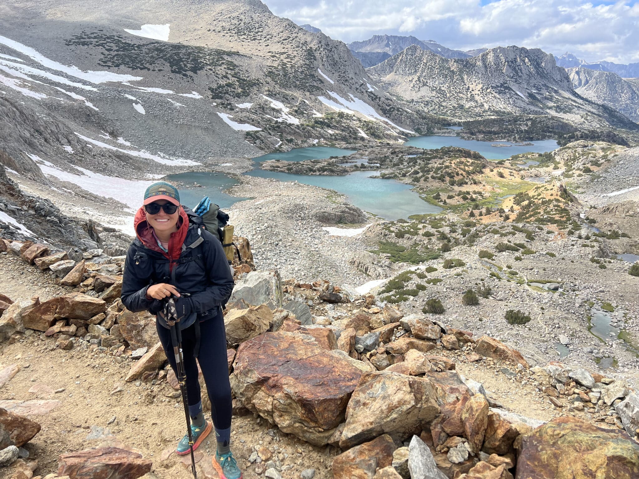A PCT Hiker standing on a high pass on the trail.